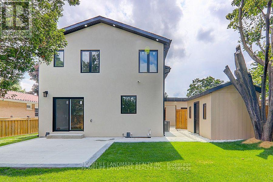 A modern house with a beige exterior and a black roof.