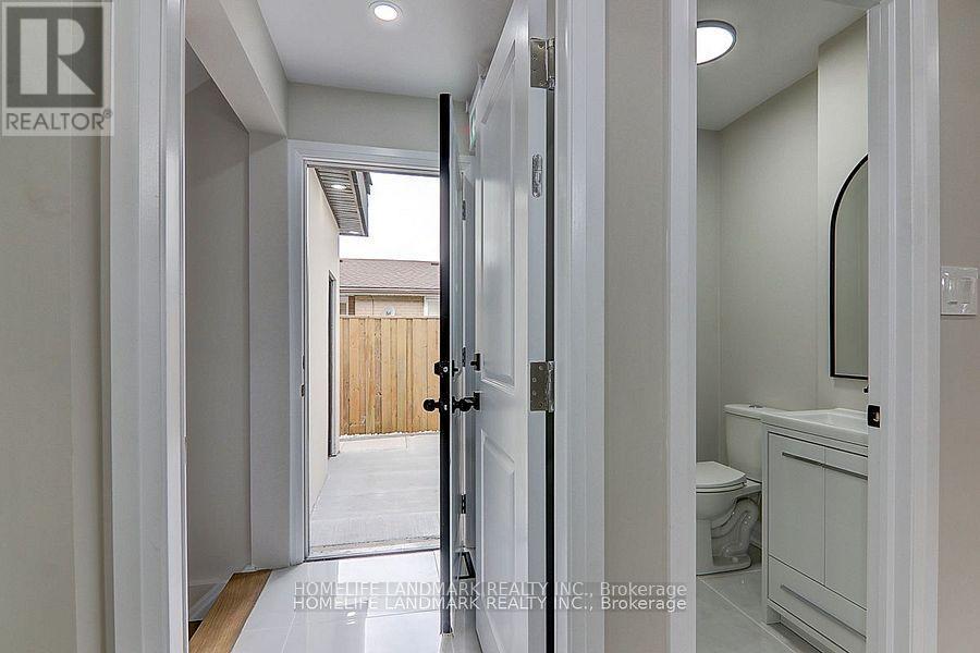 A bathroom with a toilet, sink and mirror.