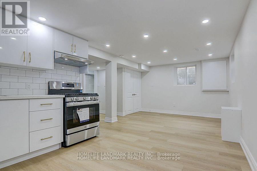 A kitchen with white cabinets and a stainless steel oven.