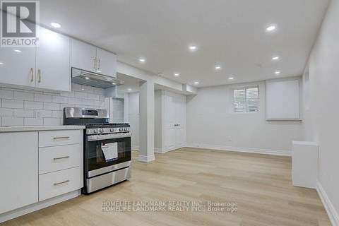 A kitchen with white cabinets and a stainless steel oven.