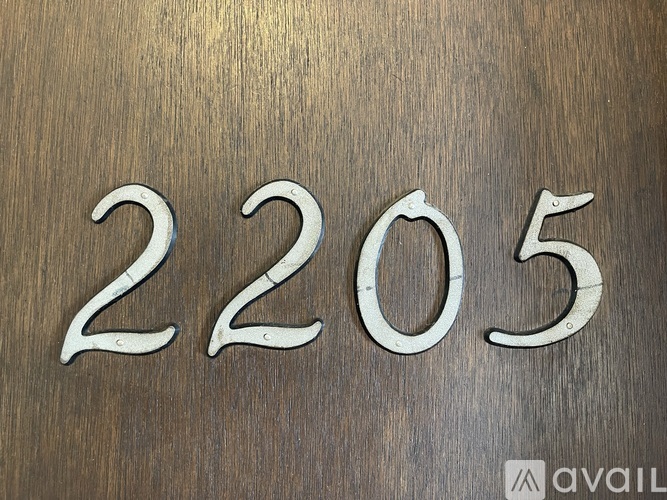 The number 2205 is displayed in a metallic font on a wooden background.