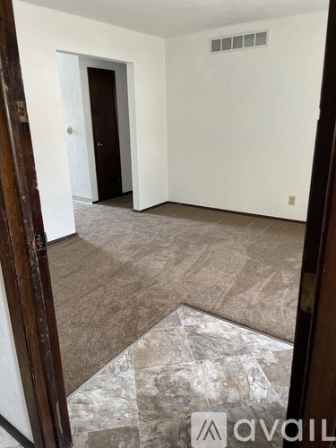 A room with a tiled floor and a door leading to another room.