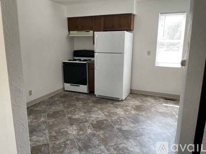 A kitchen with a white fridge and a black stove top oven.