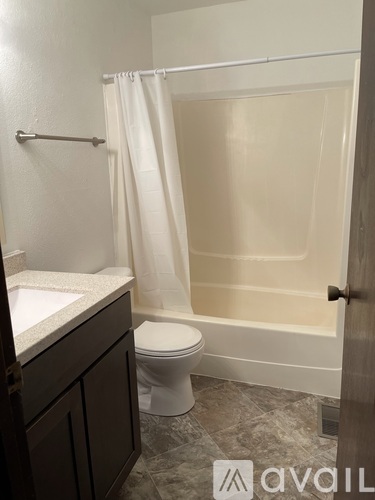 A bathroom with a toilet, sink, and shower.