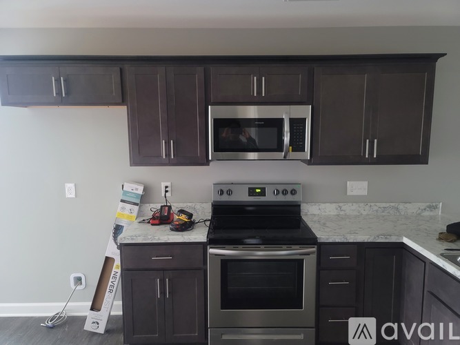 A kitchen with dark brown cabinets and stainless steel appliances.