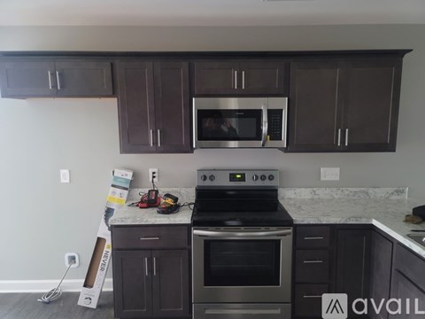 A kitchen with dark brown cabinets and stainless steel appliances.