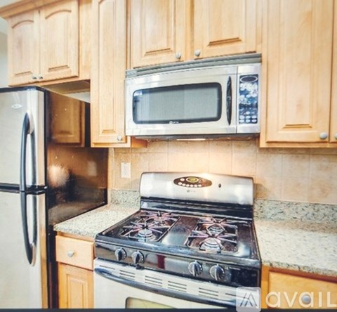 A kitchen with a stove top oven, microwave, and refrigerator.
