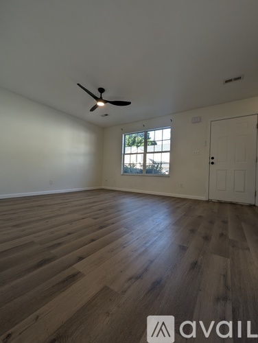 A room with wooden flooring and a ceiling fan.