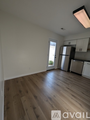 A kitchen with white cabinets and a refrigerator.