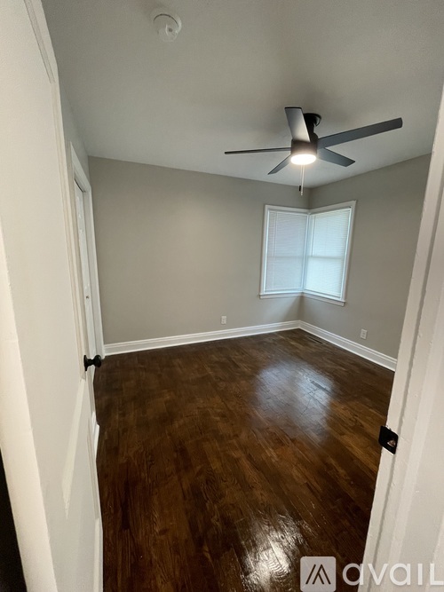 A room with a ceiling fan and a window with blinds.