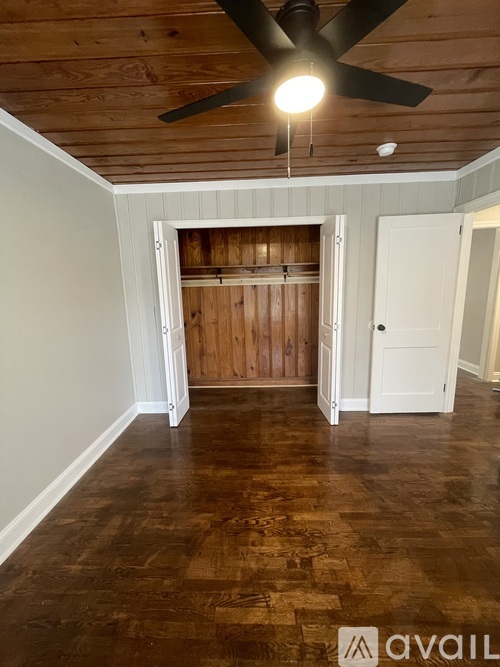 A room with wooden floors and a ceiling fan.