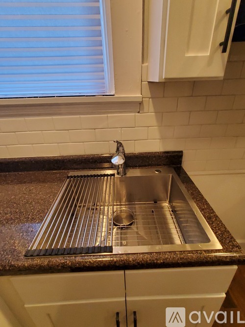 A kitchen sink with a granite counter top.