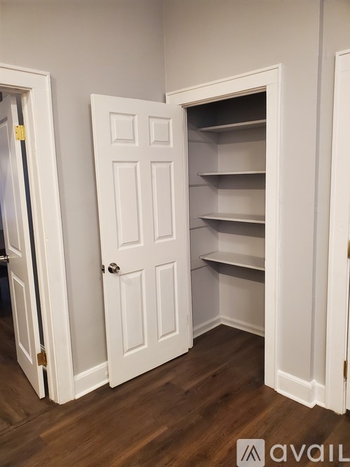 A white door with a shelf underneath it.