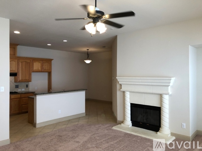 A living room with a fireplace and a ceiling fan.