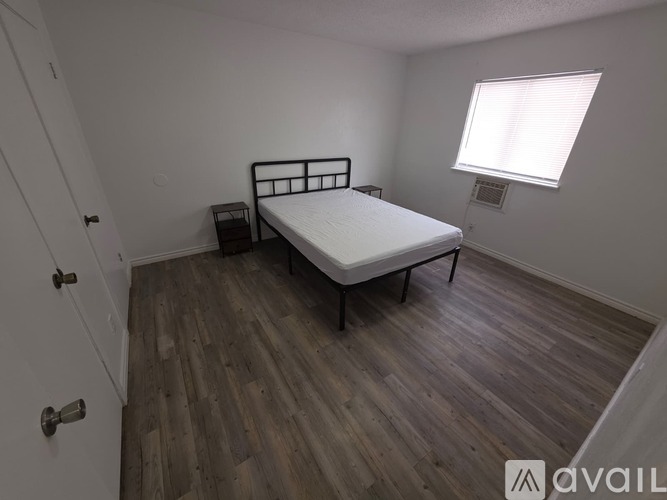A room with wooden flooring and a window.