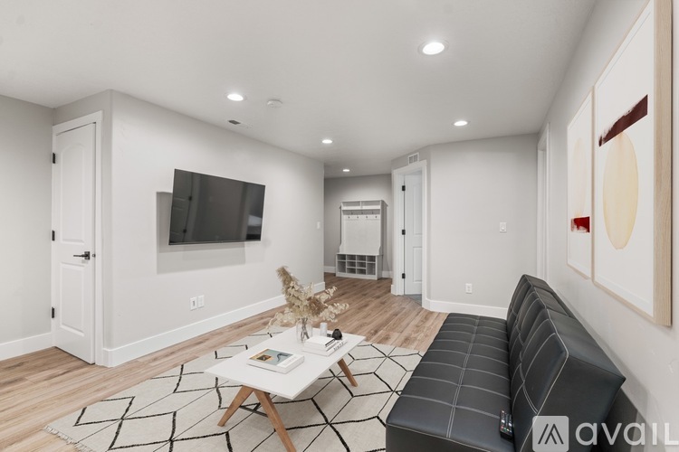 A living room with a black couch and a white coffee table.