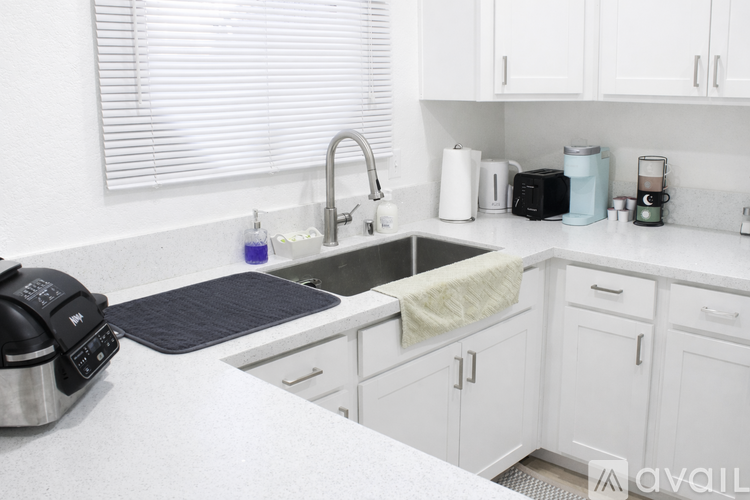 A white stove in a kitchen with white cabinets.