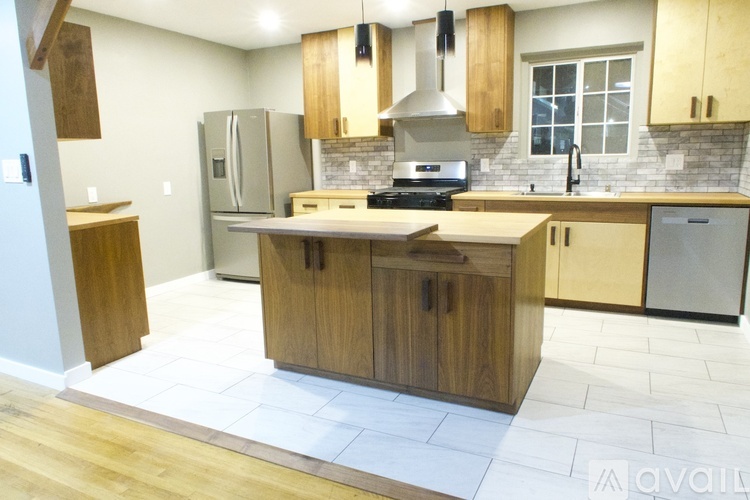 A kitchen with wooden cabinets and a brick backsplash.