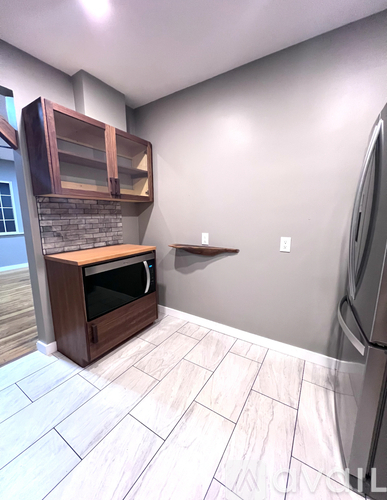 A kitchen with a refrigerator, microwave, and oven.