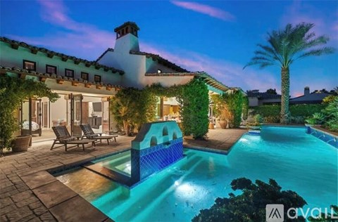A pool surrounded by palm trees and plants.