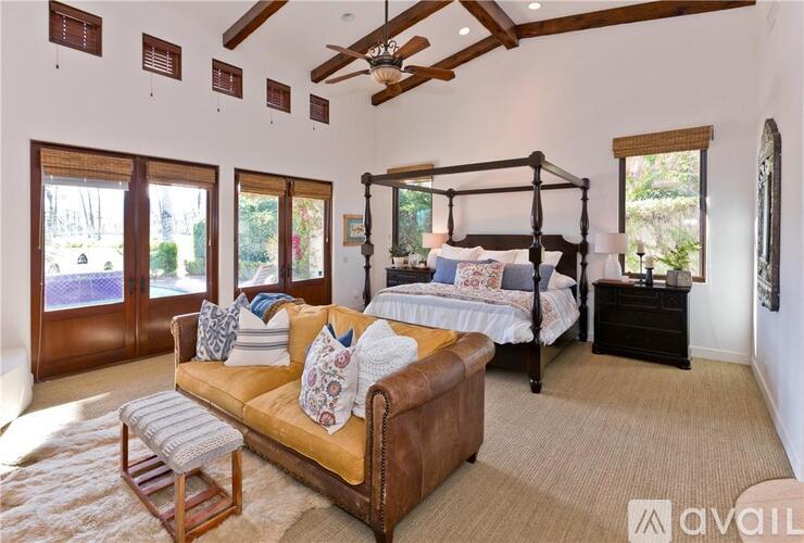 A bedroom with a four poster bed and a couch.