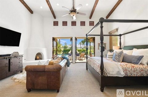 A bedroom with a four poster bed and a couch.