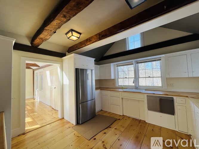 A kitchen with wooden floors and white appliances is available for rent.