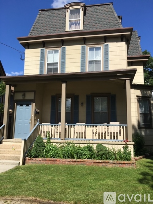 A two-story house with a blue door and white railings.
