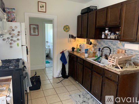 A kitchen with brown cabinets and a white refrigerator.
