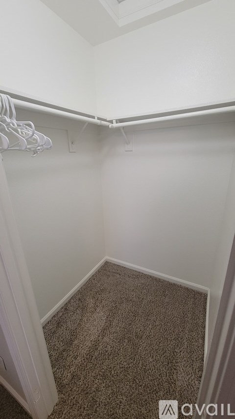 A small, empty room with a carpeted floor and a white wall.
