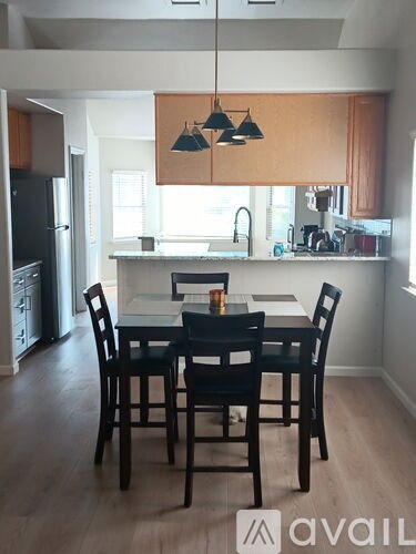 A kitchen with a table and chairs in the foreground.