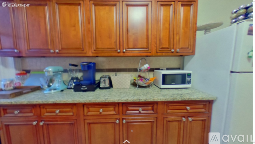 A kitchen with wooden cabinets and a granite countertop.