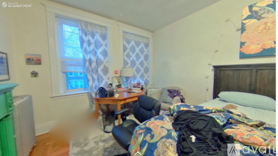A messy bedroom with a bed, desk, and chair.