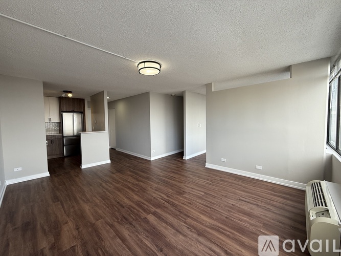 A spacious room with wooden flooring and a ceiling light.