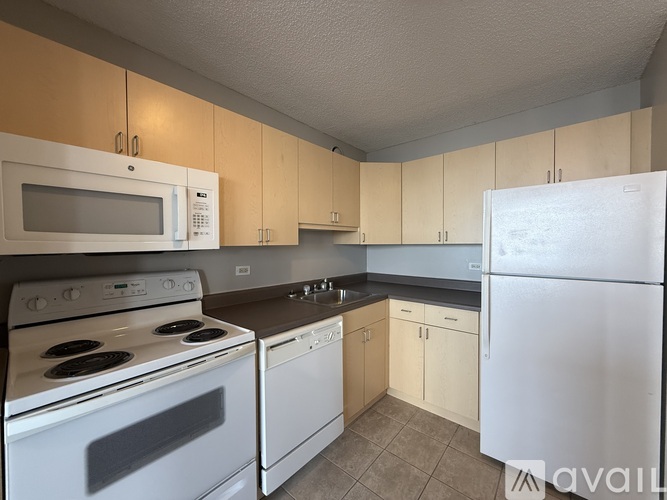 A kitchen with a white refrigerator, white stove, and white microwave.