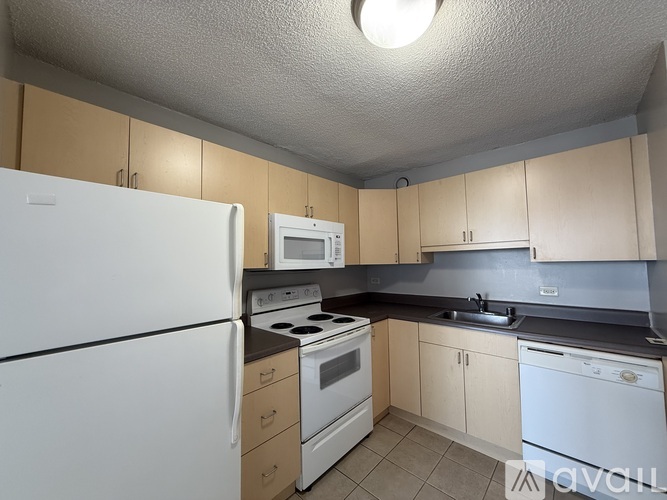 A kitchen with white appliances and beige cabinets.