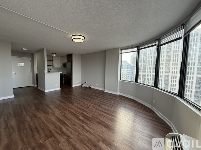 A large empty room with wooden floors and a long window.
