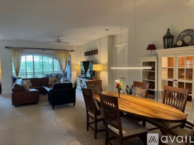 A well-lit dining room with a wooden table and chairs.