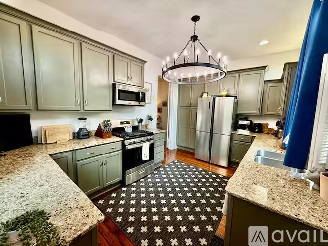 A kitchen with granite countertops and a patterned rug.