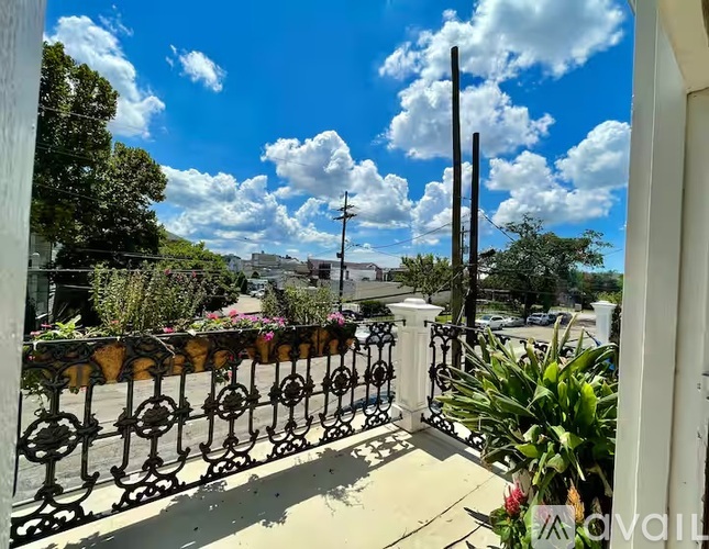 A balcony with a metal railing and a view of the street and buildings.