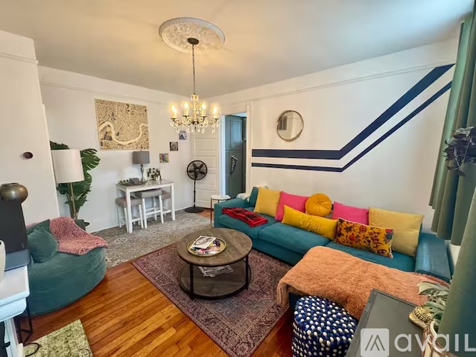 A living room with a blue couch and a chandelier.