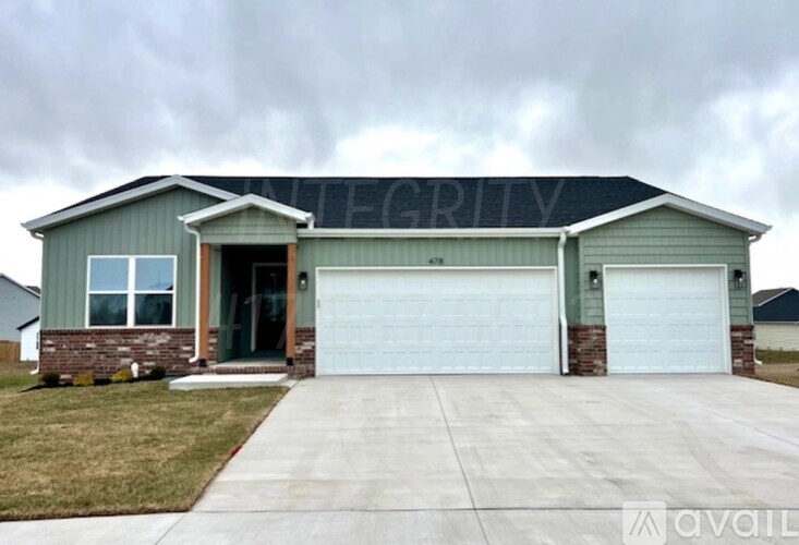 A house with a garage and a driveway in front.