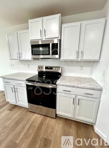 A kitchen with white cabinets and a granite countertop.