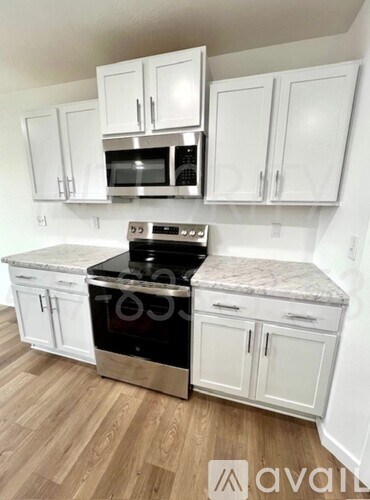 A kitchen with white cabinets and a granite countertop.
