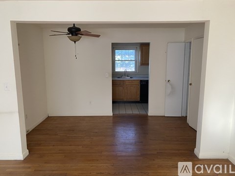 A room with a ceiling fan and wooden flooring.
