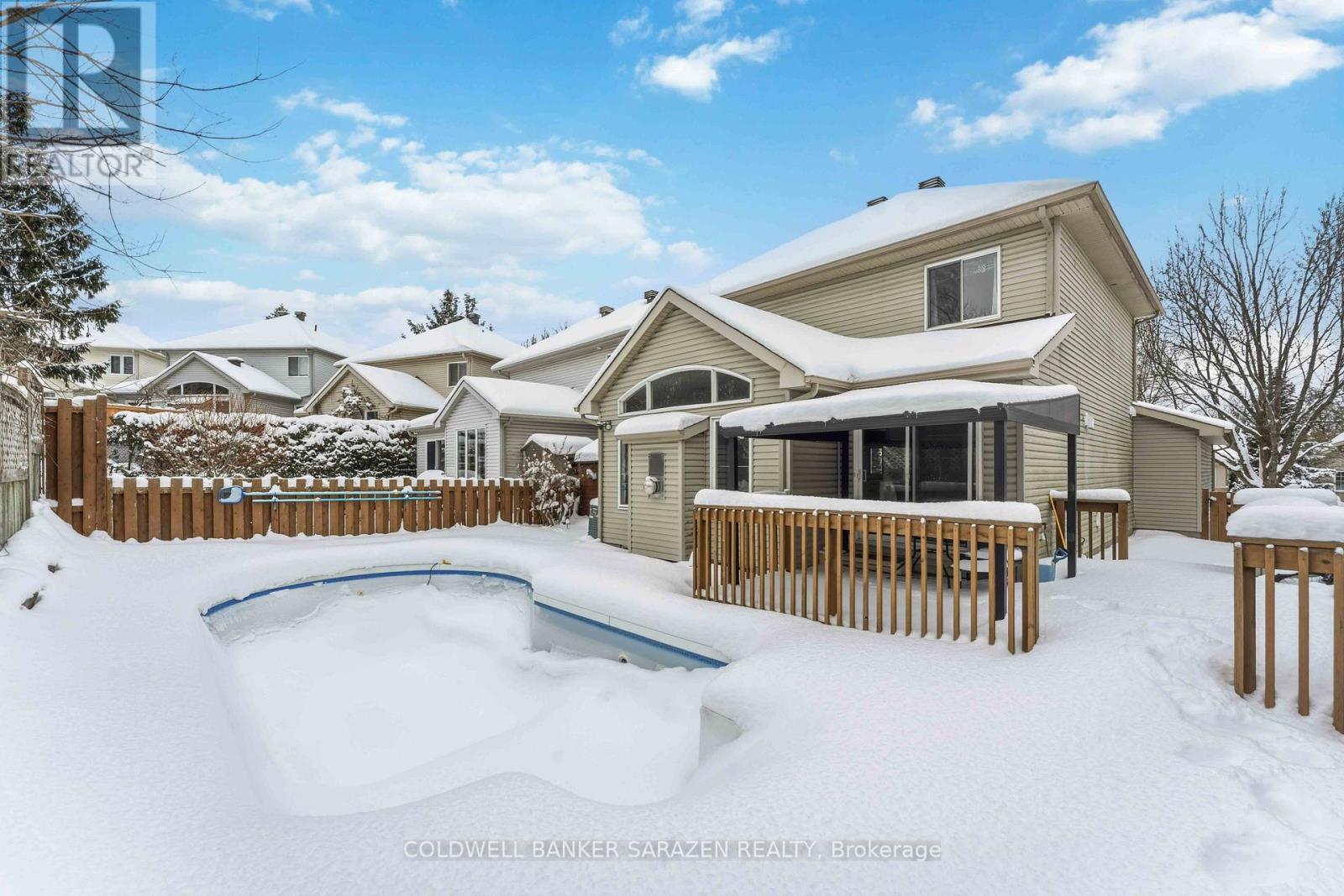A snow-covered backyard with a pool and deck.