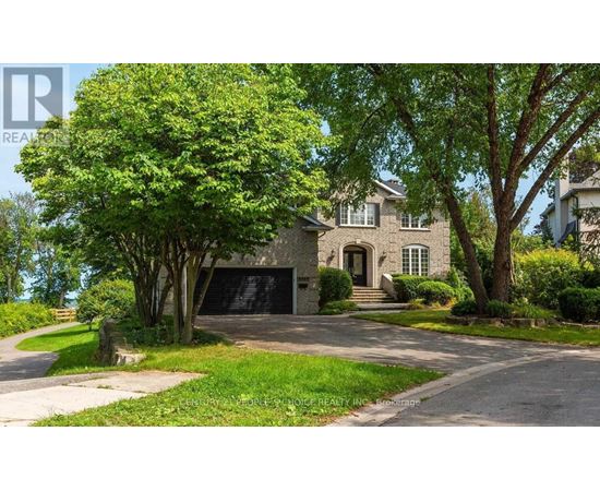 A large house with a driveway and trees in front.