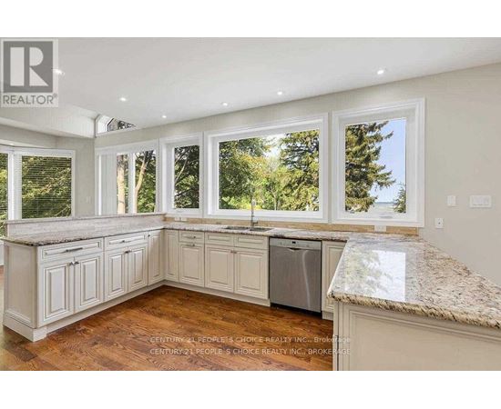 A kitchen with white cabinets and a granite countertop.