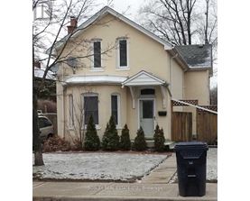 A house with a trash can in front of it.