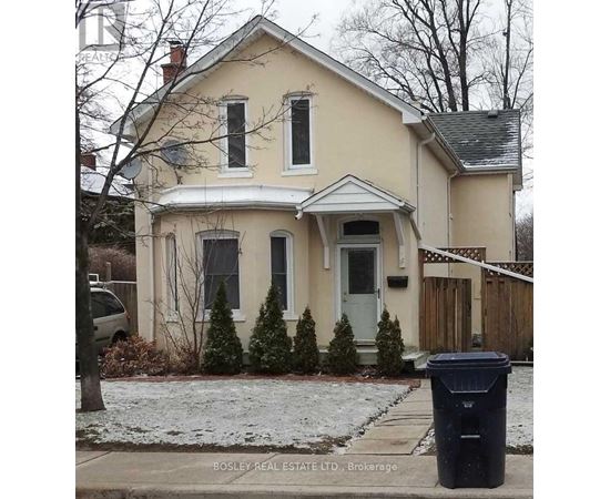 A house with a trash can in front of it.